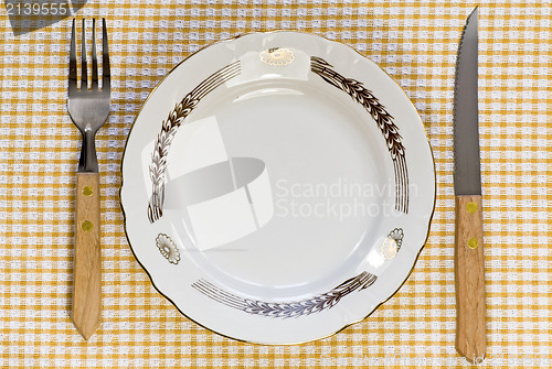 Image of plate with fork and knife on tablecloth