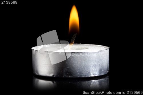 Image of burning candle in darkness 