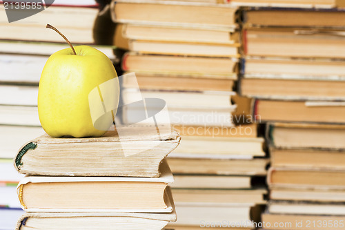 Image of yellow apple on stack of books