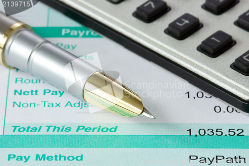 Image of pen,calculator and payslip