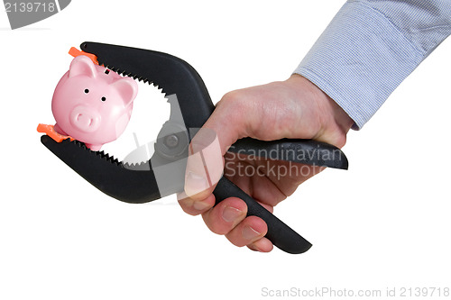 Image of businessman squeezing piggy bank in a clamp
