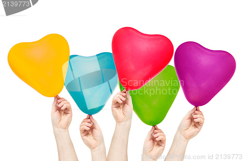 Image of Hands hold color balloons in the shape of heart