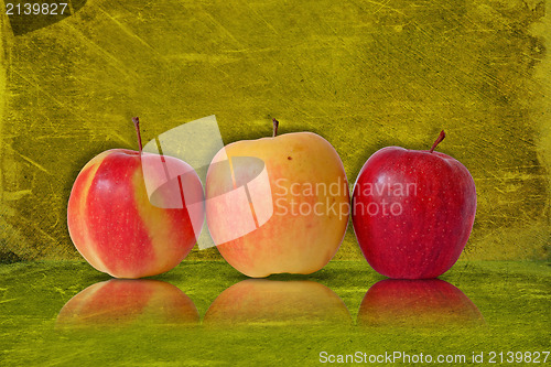 Image of three apples on green background