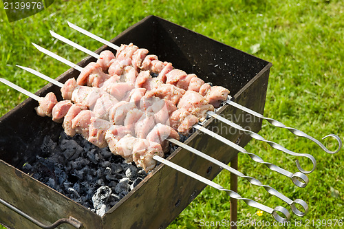 Image of meat pieces cooking on a skewer