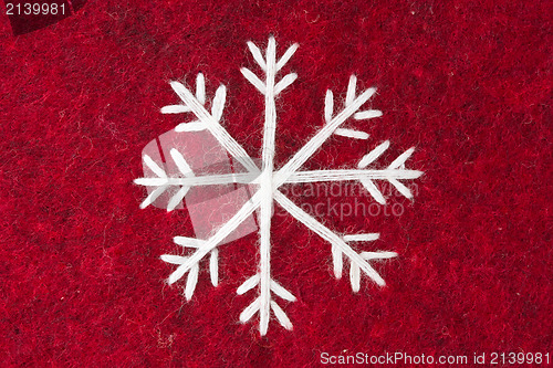 Image of red felt with embroidered white snowflake