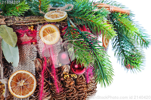 Image of Christmas-tree branch decorated with balls, beads, cinnamon and 