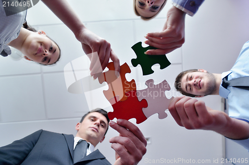 Image of Group of business people assembling jigsaw puzzle