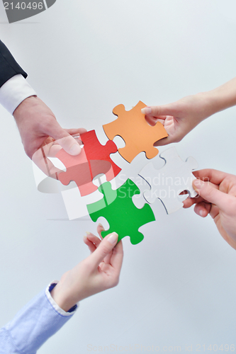 Image of Group of business people assembling jigsaw puzzle