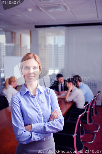 Image of business woman with her staff in background at office