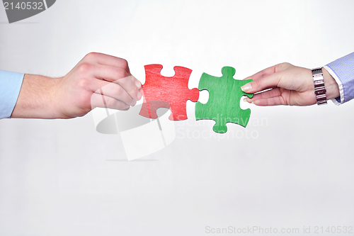 Image of Group of business people assembling jigsaw puzzle