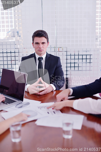 Image of business woman with her staff in background at office