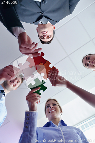 Image of Group of business people assembling jigsaw puzzle