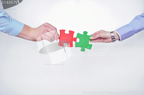 Image of Group of business people assembling jigsaw puzzle