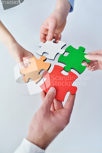 Image of Group of business people assembling jigsaw puzzle