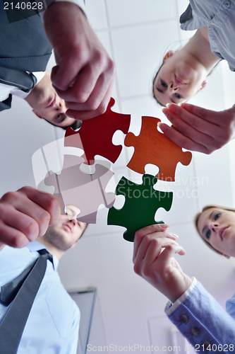 Image of Group of business people assembling jigsaw puzzle