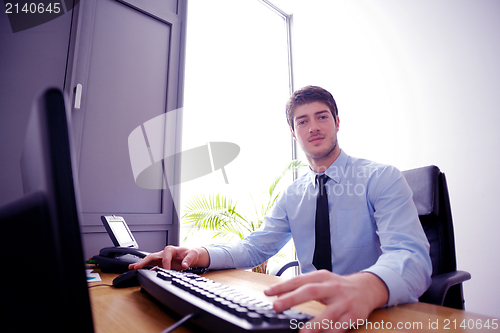 Image of happy young business man at office