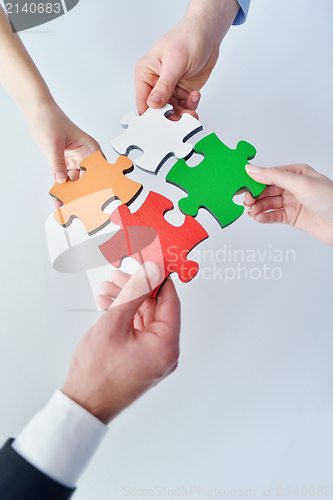 Image of Group of business people assembling jigsaw puzzle