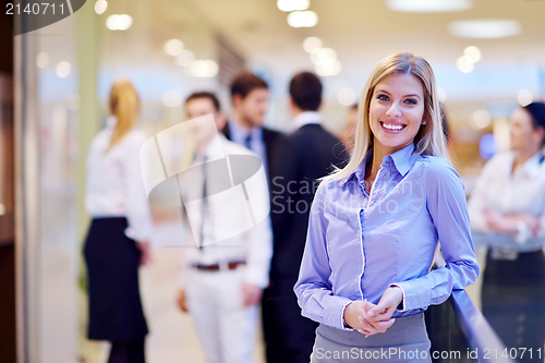 Image of business woman with her staff in background at office