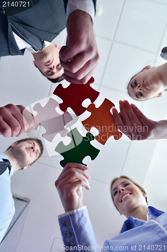 Image of Group of business people assembling jigsaw puzzle