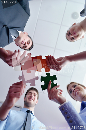 Image of Group of business people assembling jigsaw puzzle