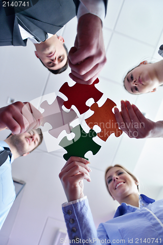 Image of Group of business people assembling jigsaw puzzle