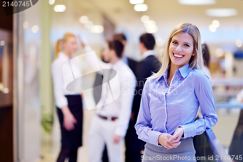 Image of business woman with her staff in background at office