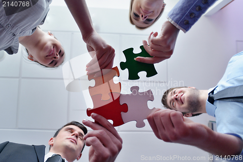 Image of Group of business people assembling jigsaw puzzle