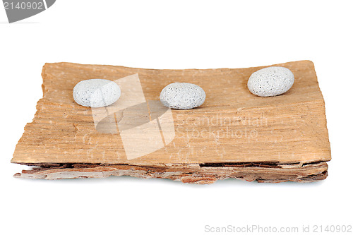 Image of three stones on a grunge wood isolated on white background