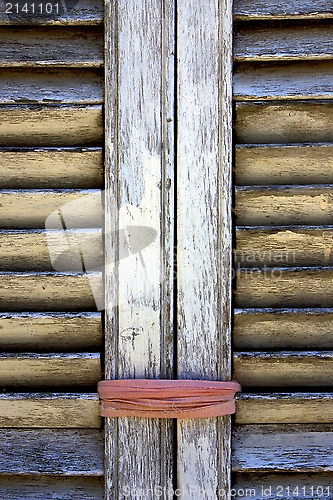 Image of brown wood venetian blind and a pink rope 