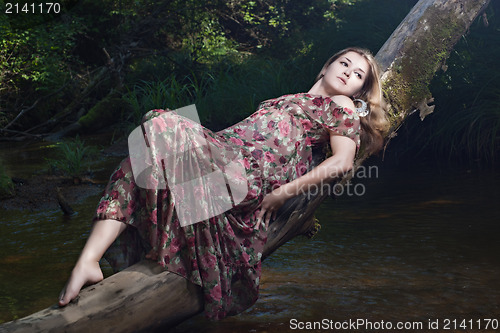 Image of Beautiful girl in the national dress and hat stand in the river 