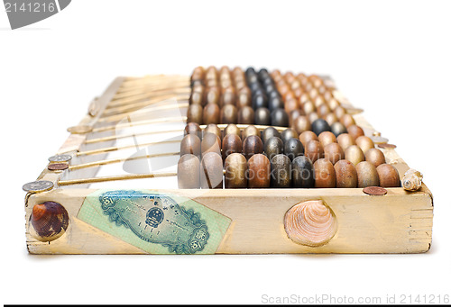 Image of abstract composition from the old wooden abacus, coins and shell