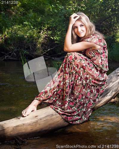 Image of Beautiful girl in the national dress stand in the  forest nearth