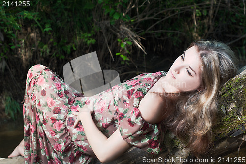 Image of Beautiful girl in the national dress stand in the river in the  