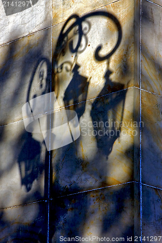 Image of shadow of a street lamp and a yellow orange marble