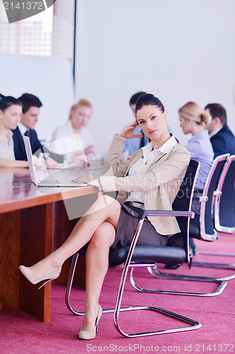 Image of business woman with her staff in background at office