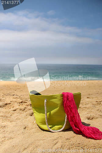 Image of Green beach bag on the seacoast and pink shawl  