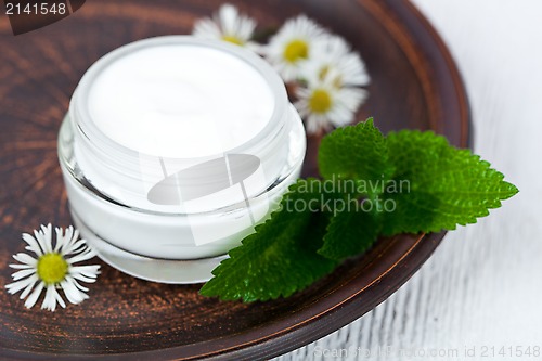 Image of container with cream urtica and chamomiles 