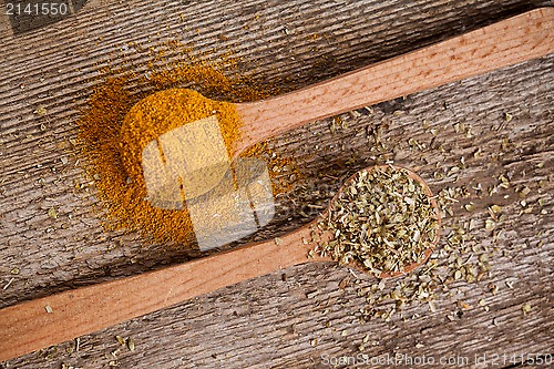 Image of two spices in wooden spoons 