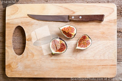 Image of figs and old knife on wooden board