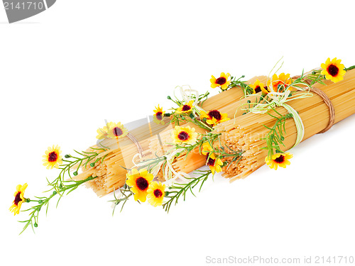 Image of Uncooked Italian spaghetti decorated with yellow flowers isolate