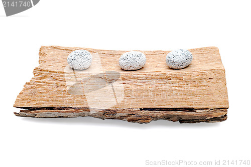 Image of Three stones on a grunge wood isolated on white