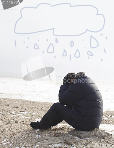 Image of Lonely man sitting on sand