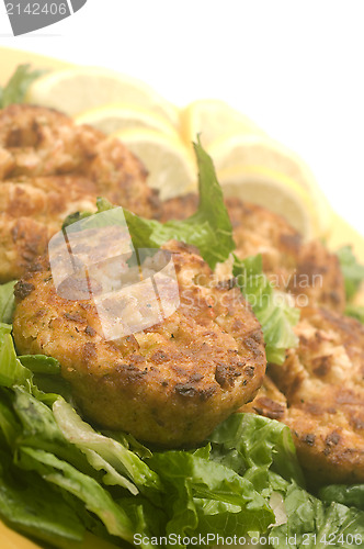 Image of lobster cakes  bed of lettuce with lemon slice wedges