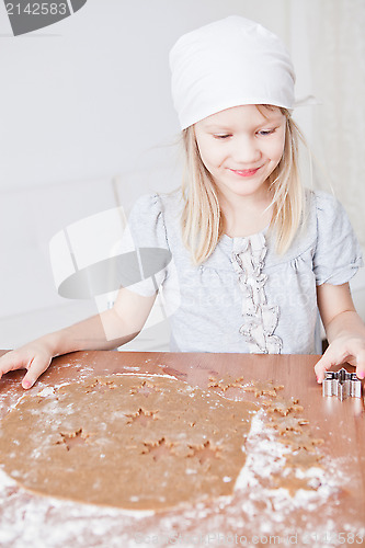 Image of Happy young girl making gingerbread