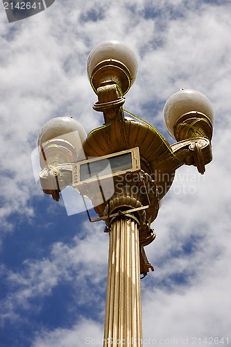 Image of gold street lamp  and a cloudy sky  in buenos aires 