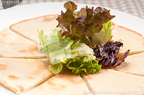 Image of garlic pita bread pizza with salad on top