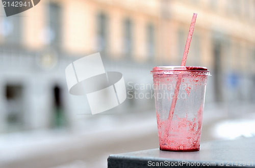 Image of empty dirty plastic cup and cocktail straw outdoor