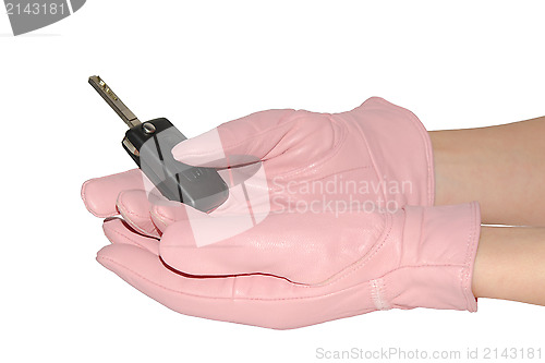 Image of Car key in female hands in pink gloves