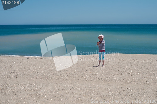 Image of Small girl playing on the beach