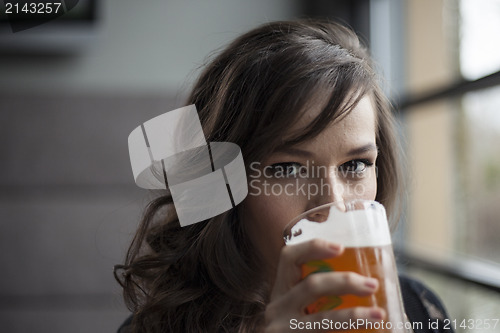 Image of Young Woman Drinking a Pint Glass of Pale Ale